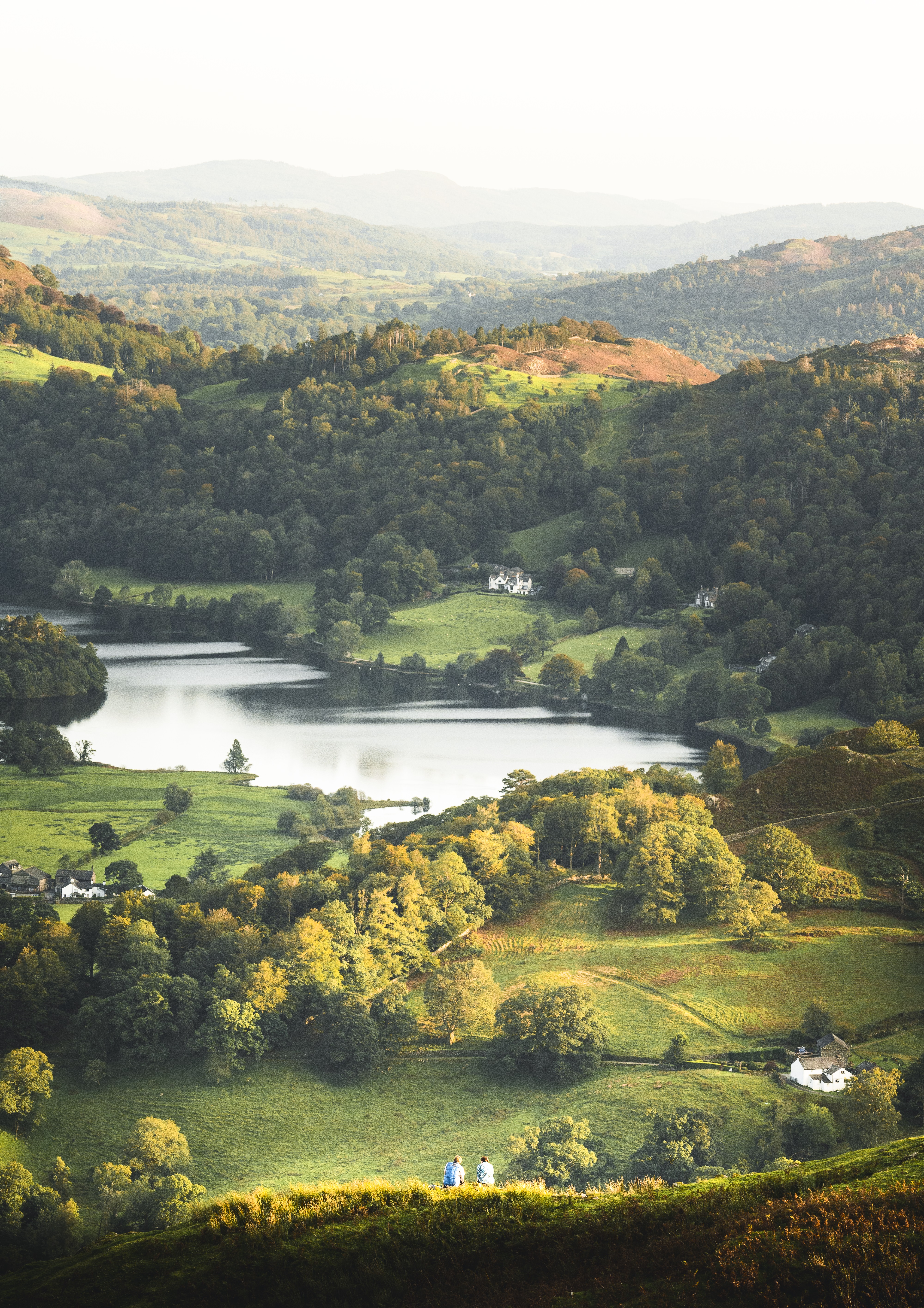 View from above of green rolling hills and a lake nearby