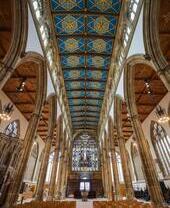 Looking up inside to the intricate ornate ceiling of an old church.