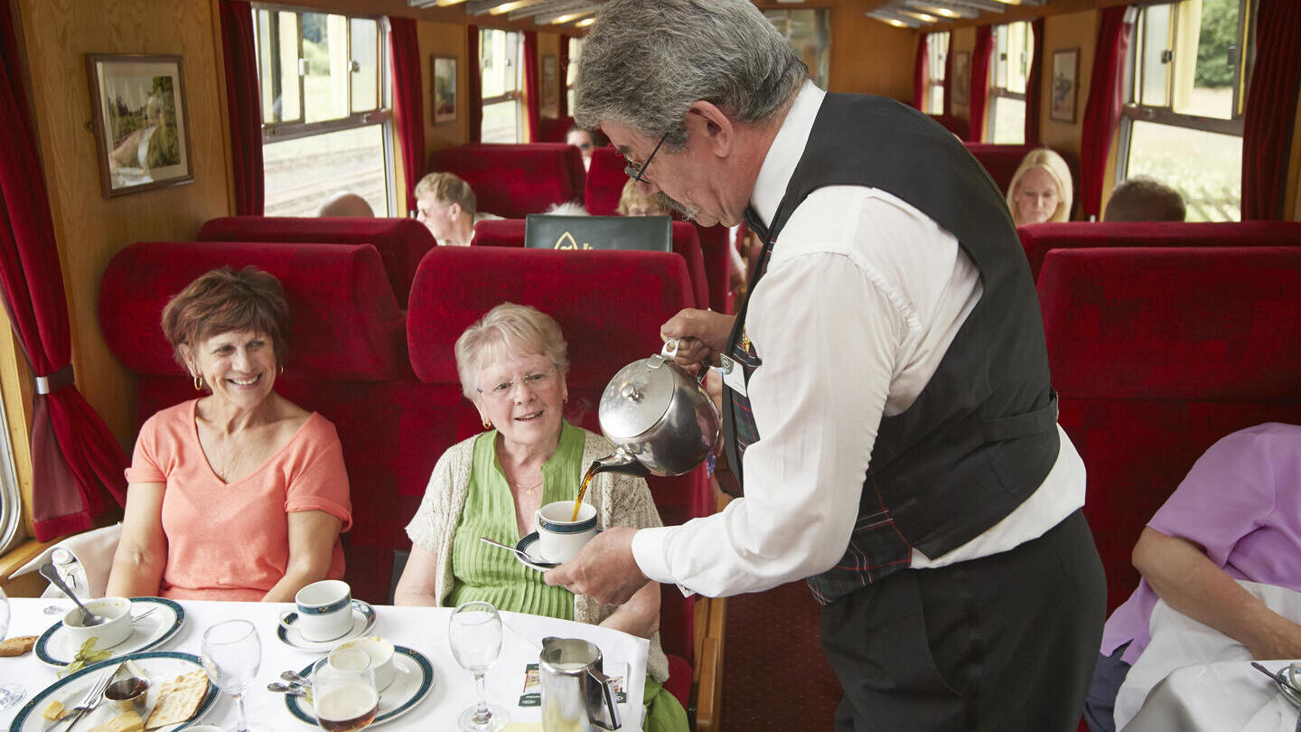 On board staff serving coffee on the Pullman Dining Train.