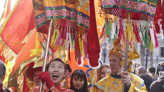 فنانين يرتدون أزياء صينية ملونة يؤدون عرضًا