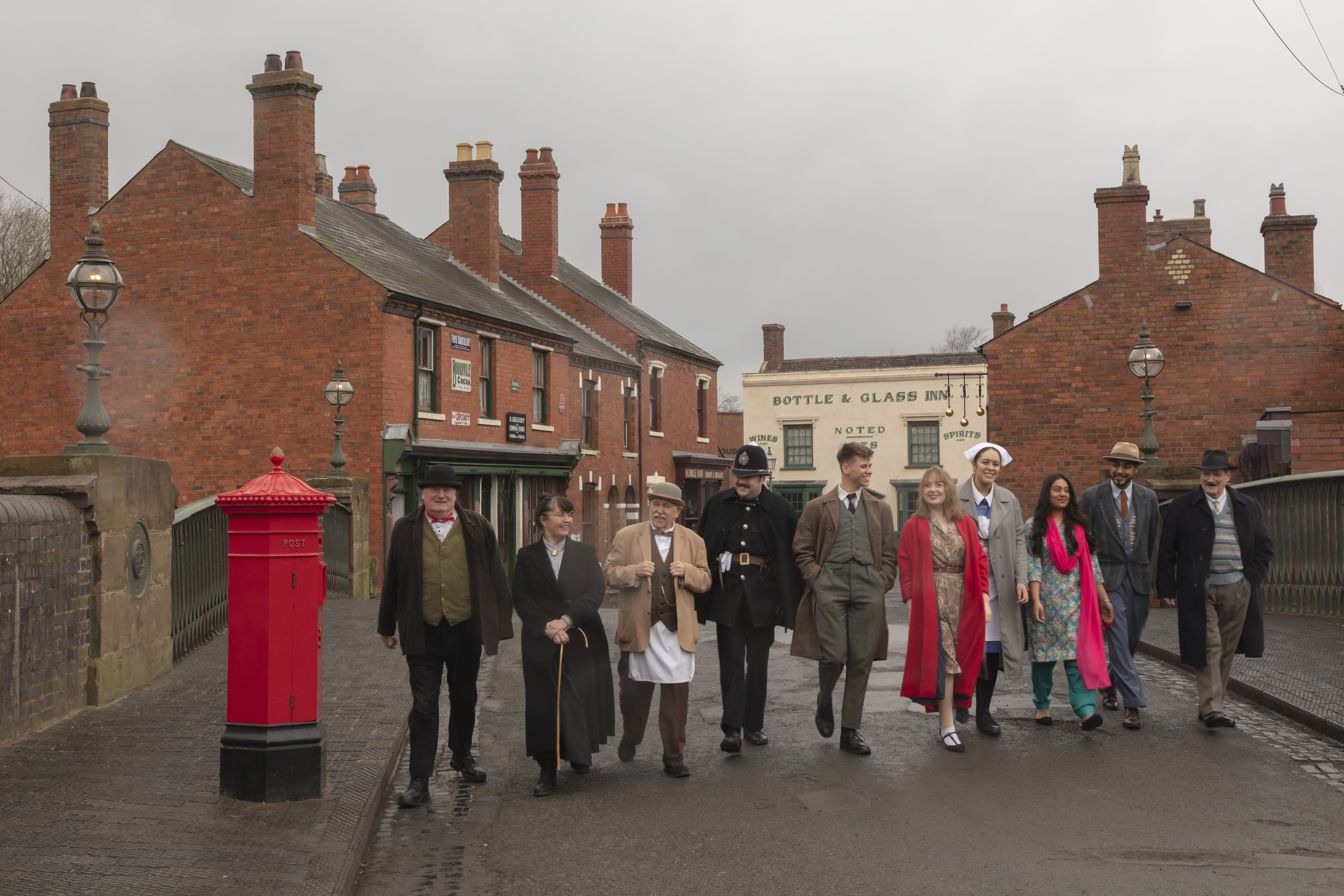 Gruppo di persone che camminano su una strada in un museo vivente