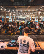 DJ playing to groups of people at Manchester Craft Beer Festival, in Depot Mayfield, Manchester