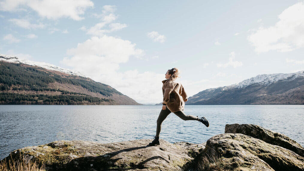 UK, Scotland, young woman running at Loch Lomond