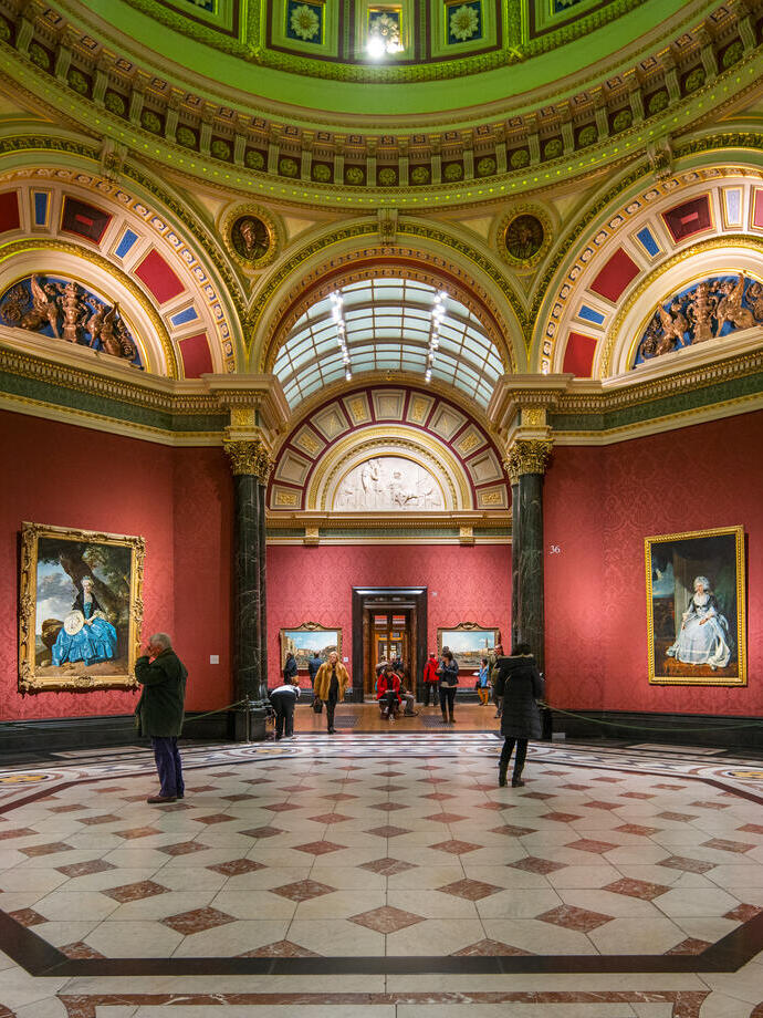 People viewing paintings inside the National Gallery in London