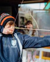Un niño practicando tiro con arco en Heatherton World of Activities