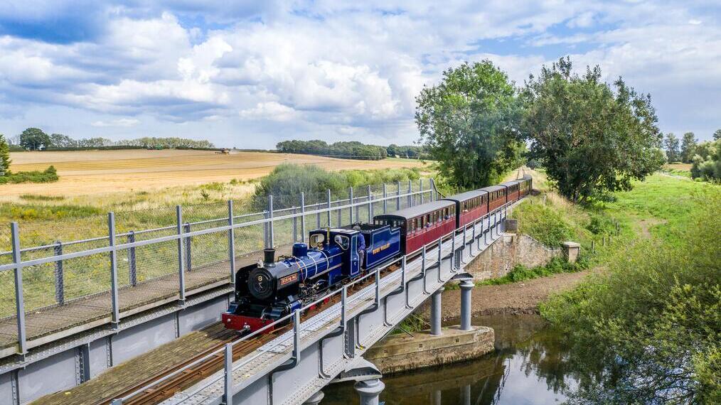 Un train à vapeur passant au-dessus d'une rivière dans le parc national des Broads