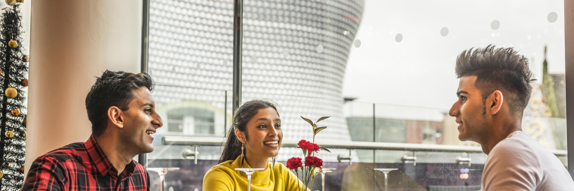 Tre giovani seduti a un tavolo da pranzo con vista panoramica