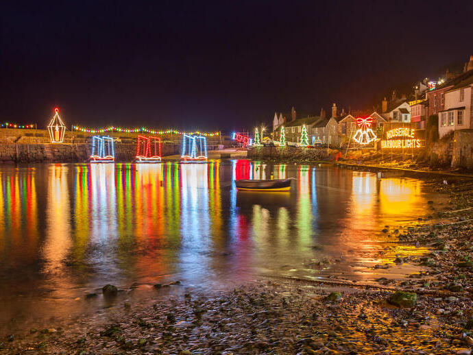 A beautiful evening display of Christmas lights reflecting over a quaint English village & harbour.