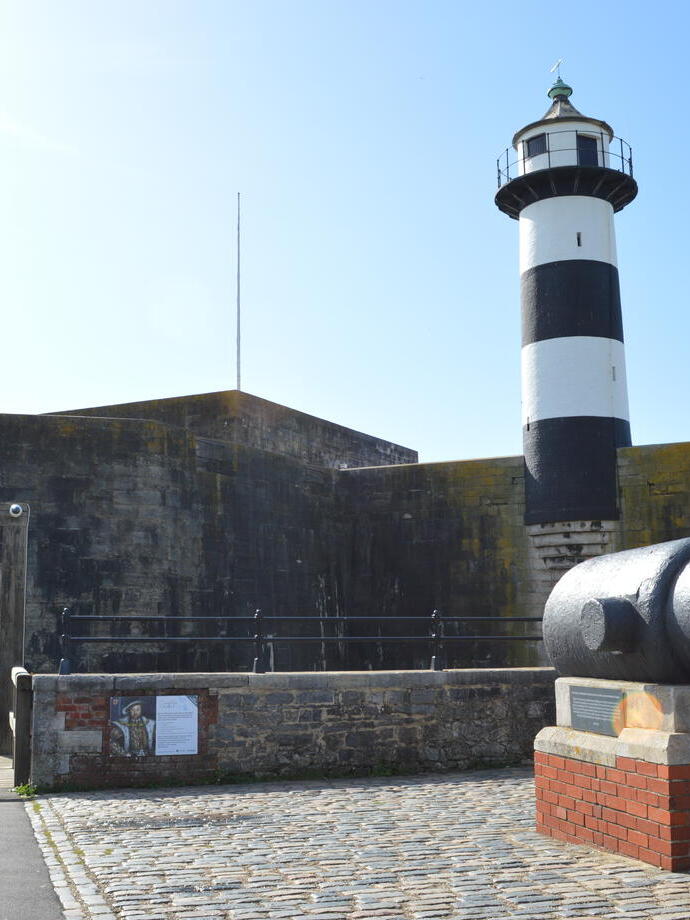 A lighthouse and cannon in the grounds of an old castle