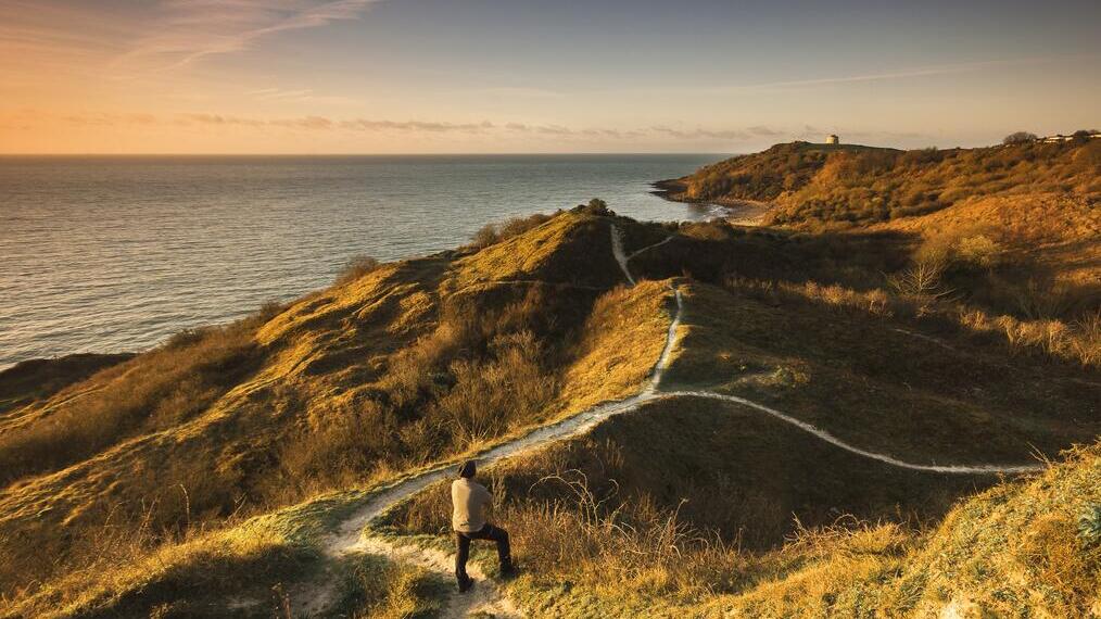 Man standing on coastal path near the sea