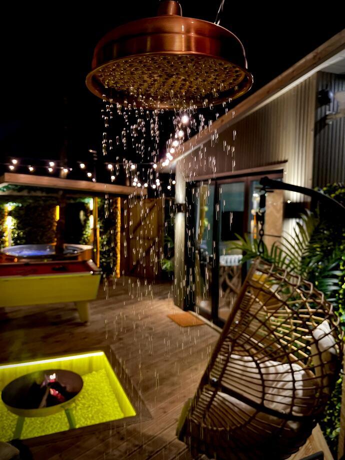 Outdoor area taken at night with a copper overhead shower at The Secret Garden Glamping, Lancashire