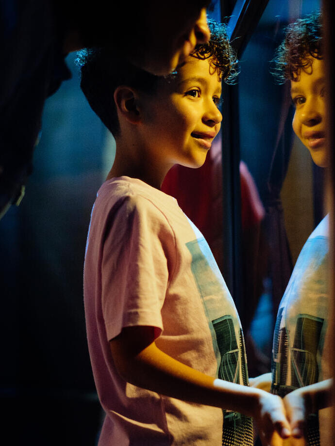 Young boy, leaning, looking through the glass and smiling
