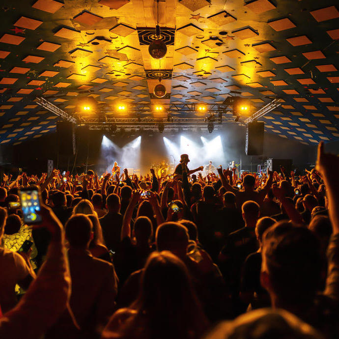 Fiesteros disfrutando del baile en una sala de música y salón de baile.