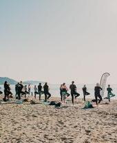 A yoga class being undertaken on a beach in Cornwall