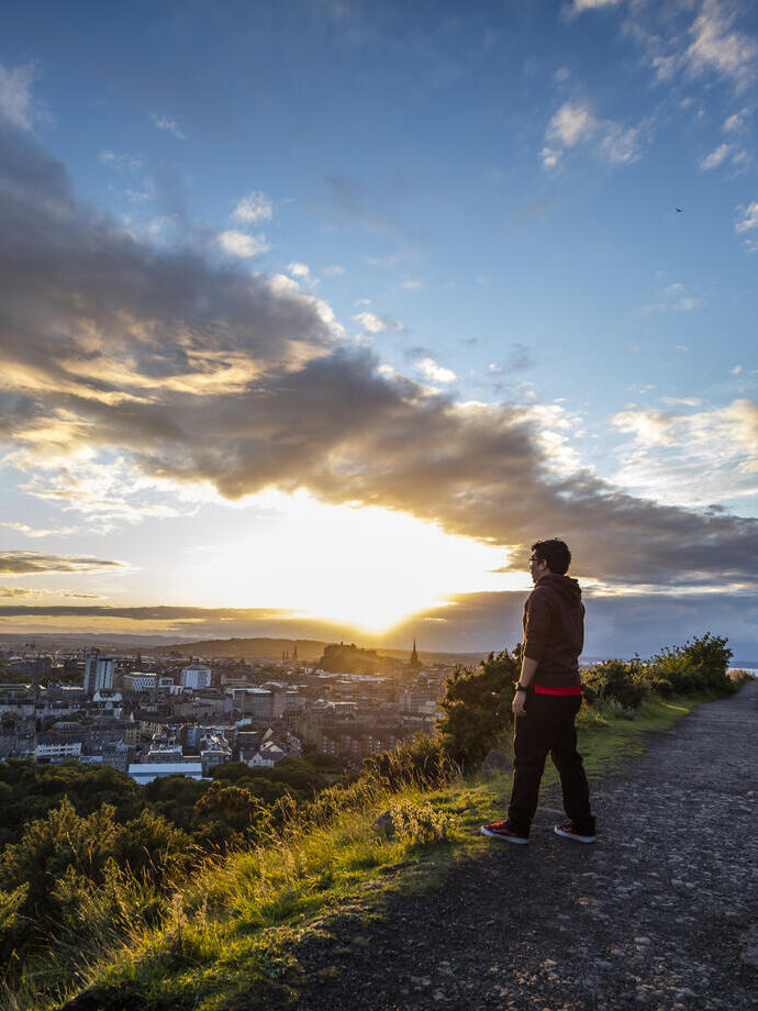 Hombre disfrutando de las vistas panorámicas de Edimburgo desde la cima de Arthur's Seat