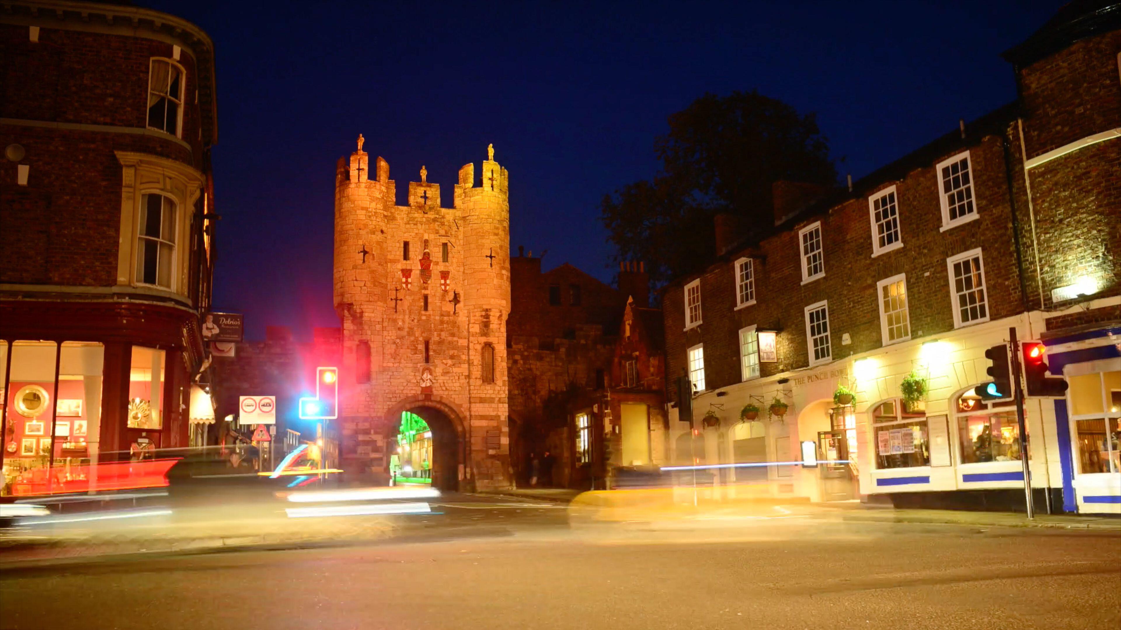 Traffic passing micklegate bar at twilight in york