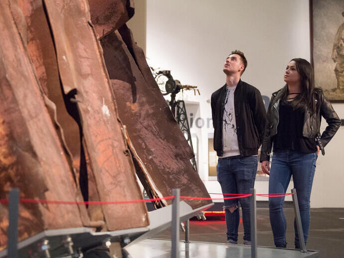 Two people looking upwards at an exhibit in Manchester Imperial War Museum
