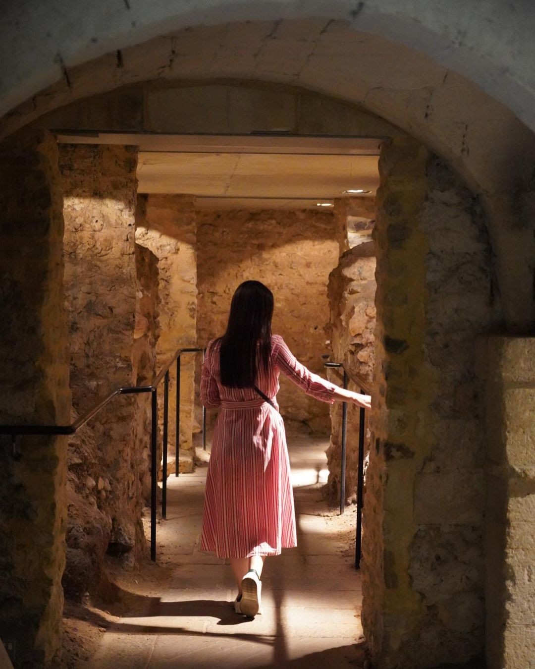Woman exploring underground rooms at Oxford Castle
