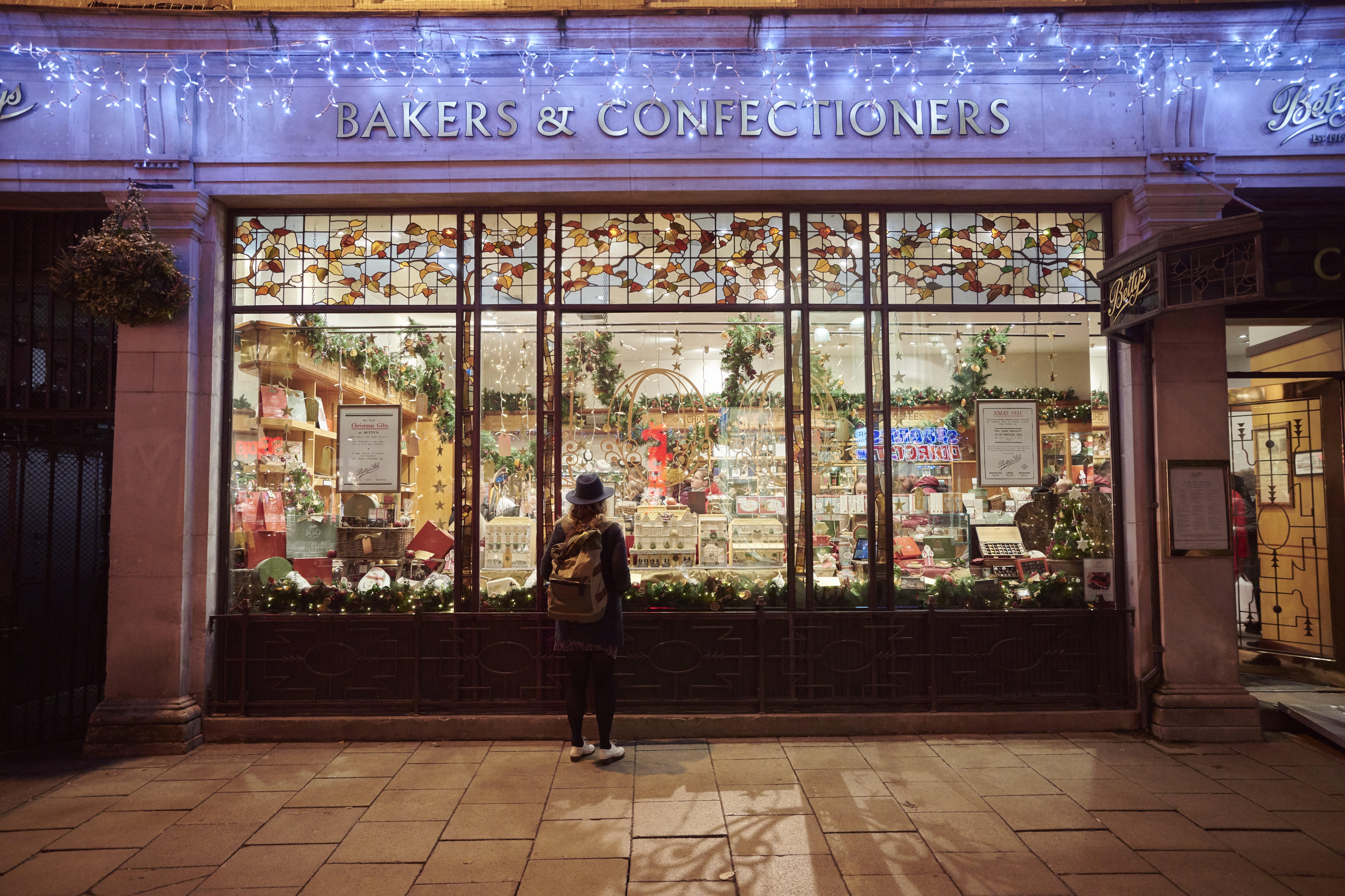 Woman looking into a shop window in the evening at Christmas