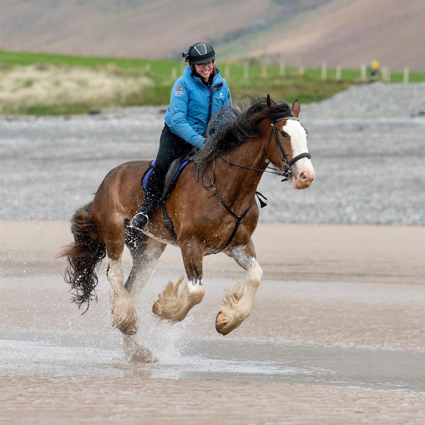 امرأة تمتطي حصانًا في البحر في شمال شرق إنجلترا