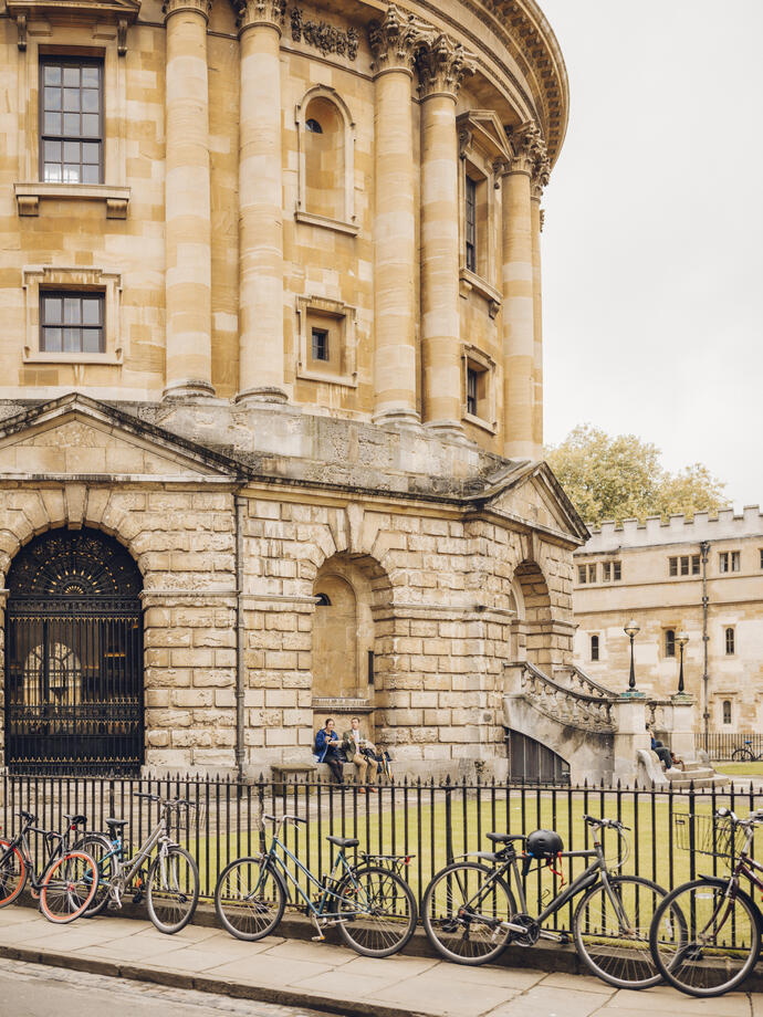 شخصان يجلسان تحت قوس خارج مبنى تاريخي