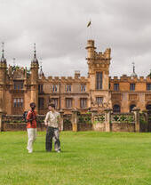 Two young men walk in the grounds of a heritage house
