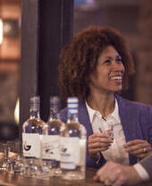 Una pareja degustando whisky con tres botellas delante de ellos.