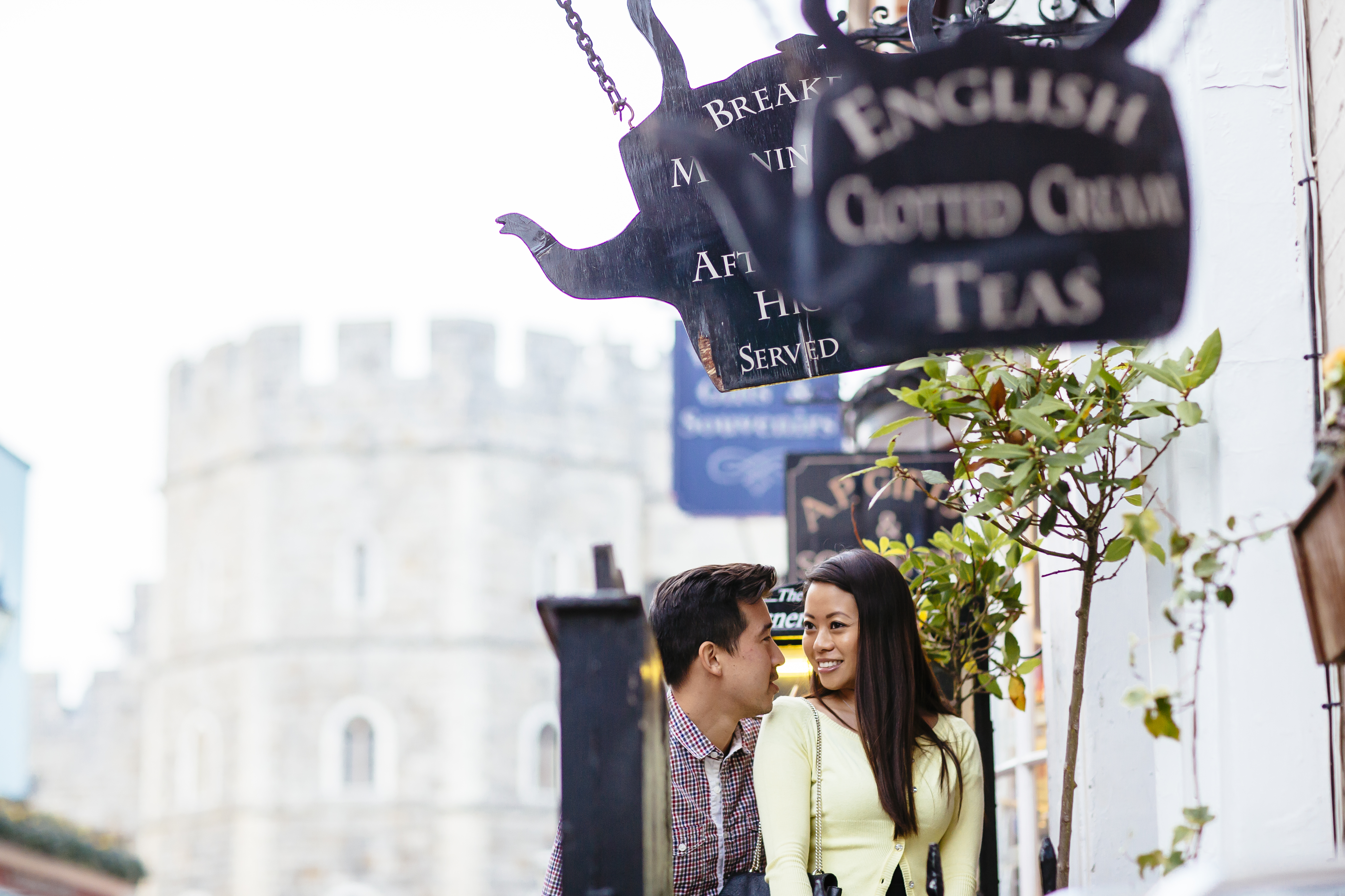 Couple in a street near tea shops and a castle in the background