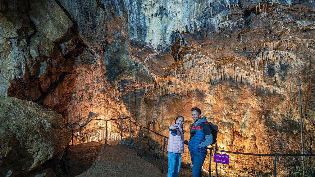 Ein Mann und eine Frau machen mit ihrem Handy ein Selfie in einer Höhle
