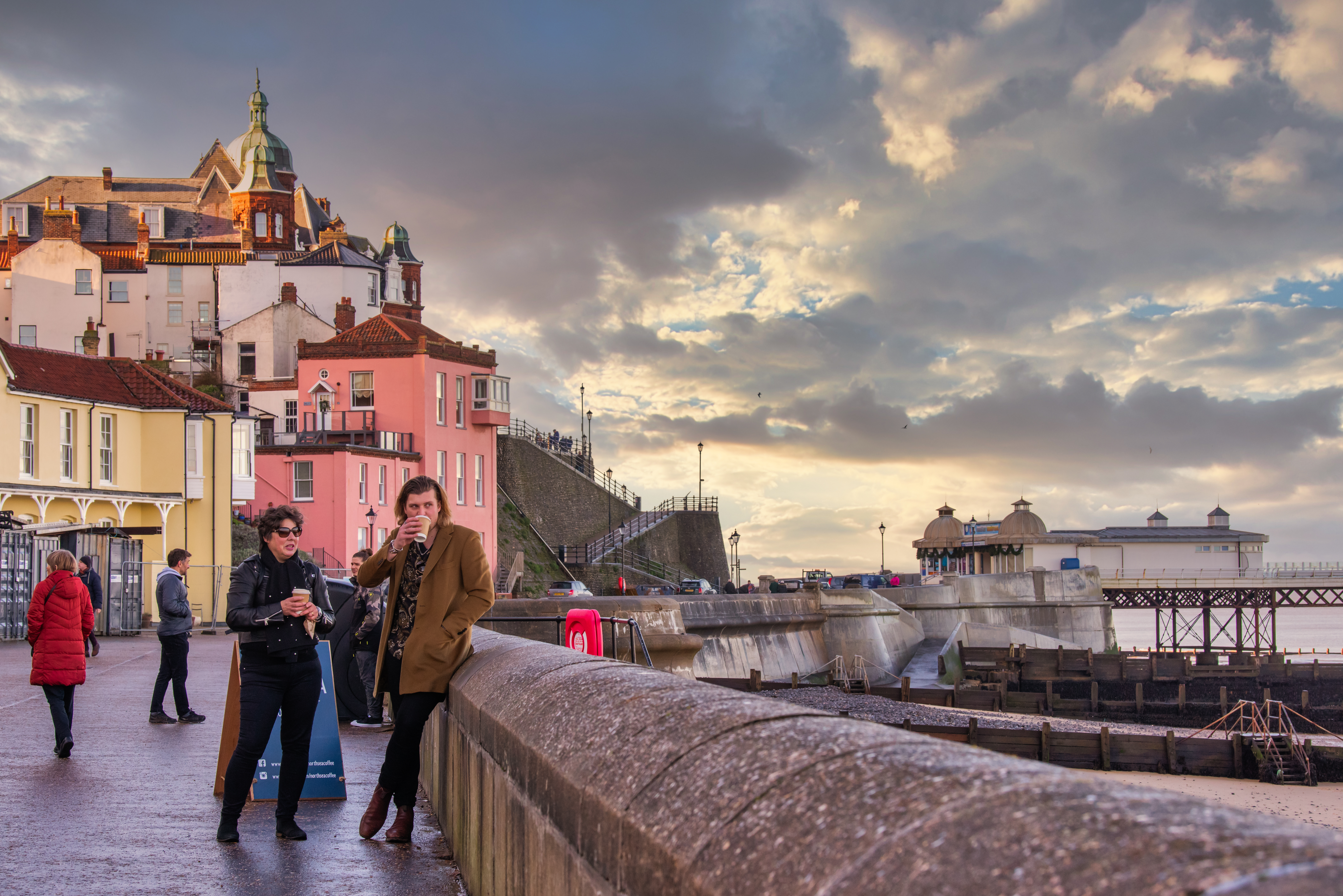 Groups of people stood on the promenade looking out on Cromer Beach