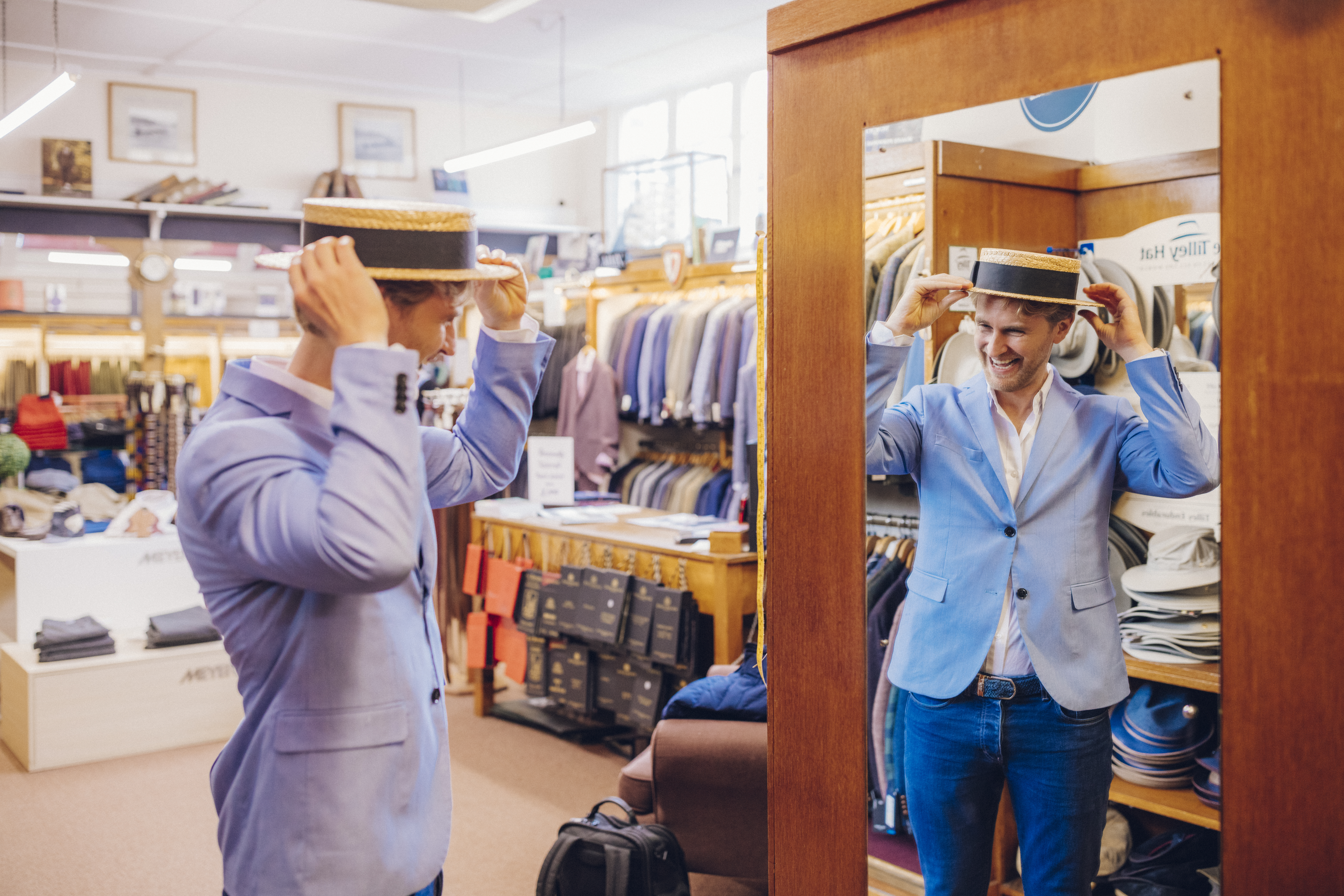 Man trying on a traditional straw hat in a clothes shop