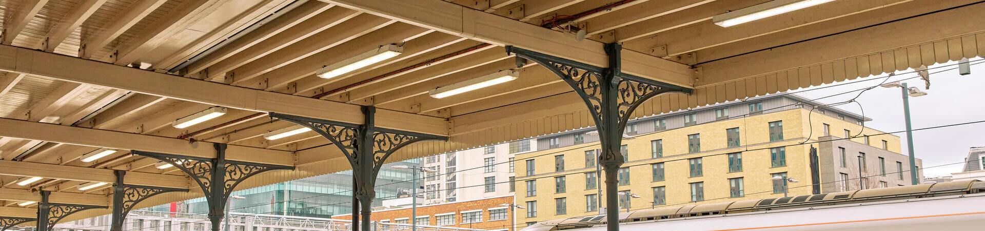 Man and woman walk along a train station platform