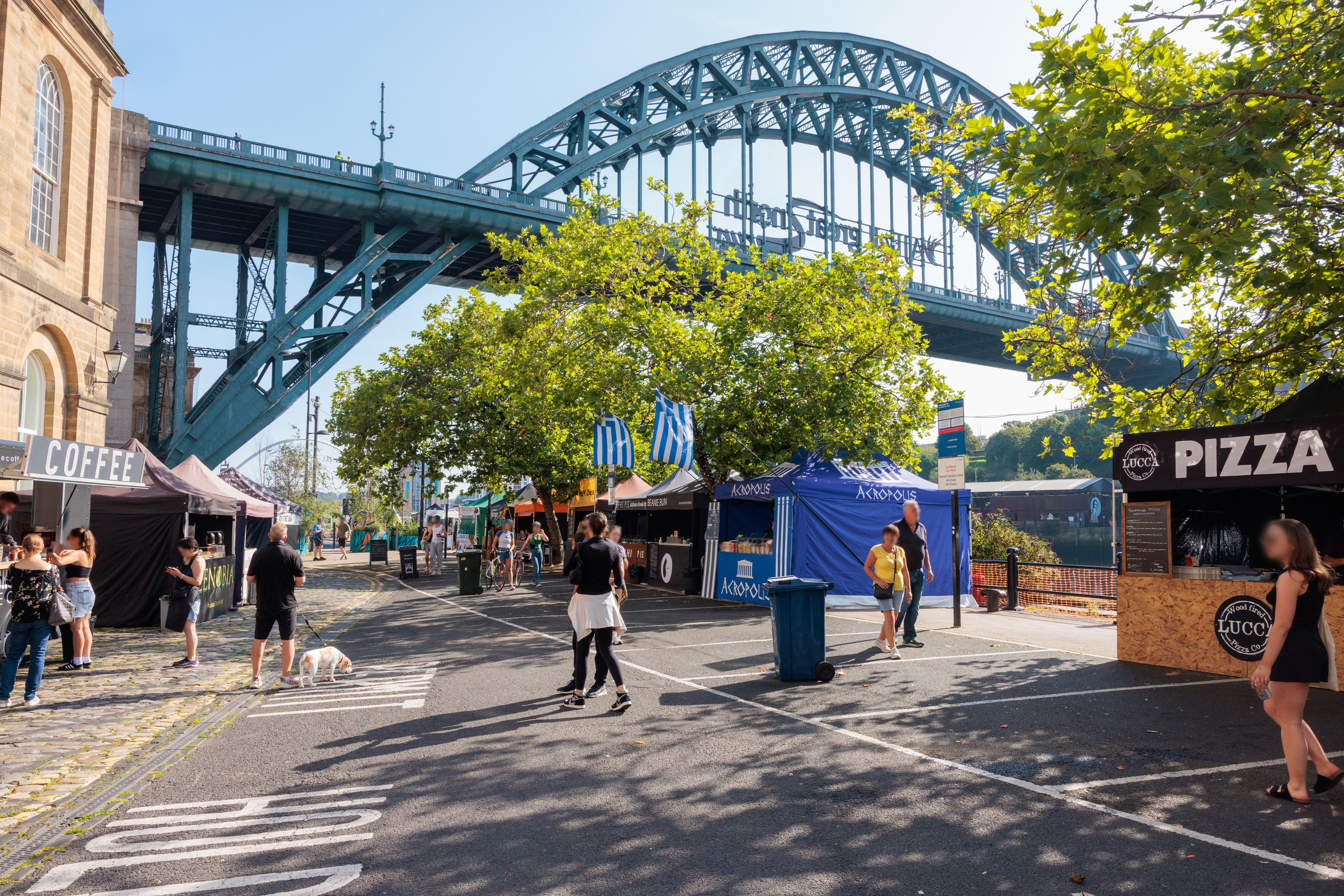 Menschen, die an Marktständen in der Nähe einer Brücke vorbeigehen