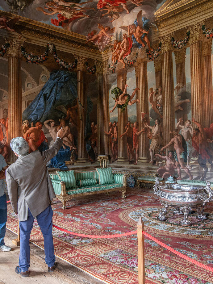 Un homme et une femme avec un guide touristique dans une salle décorée de peintures