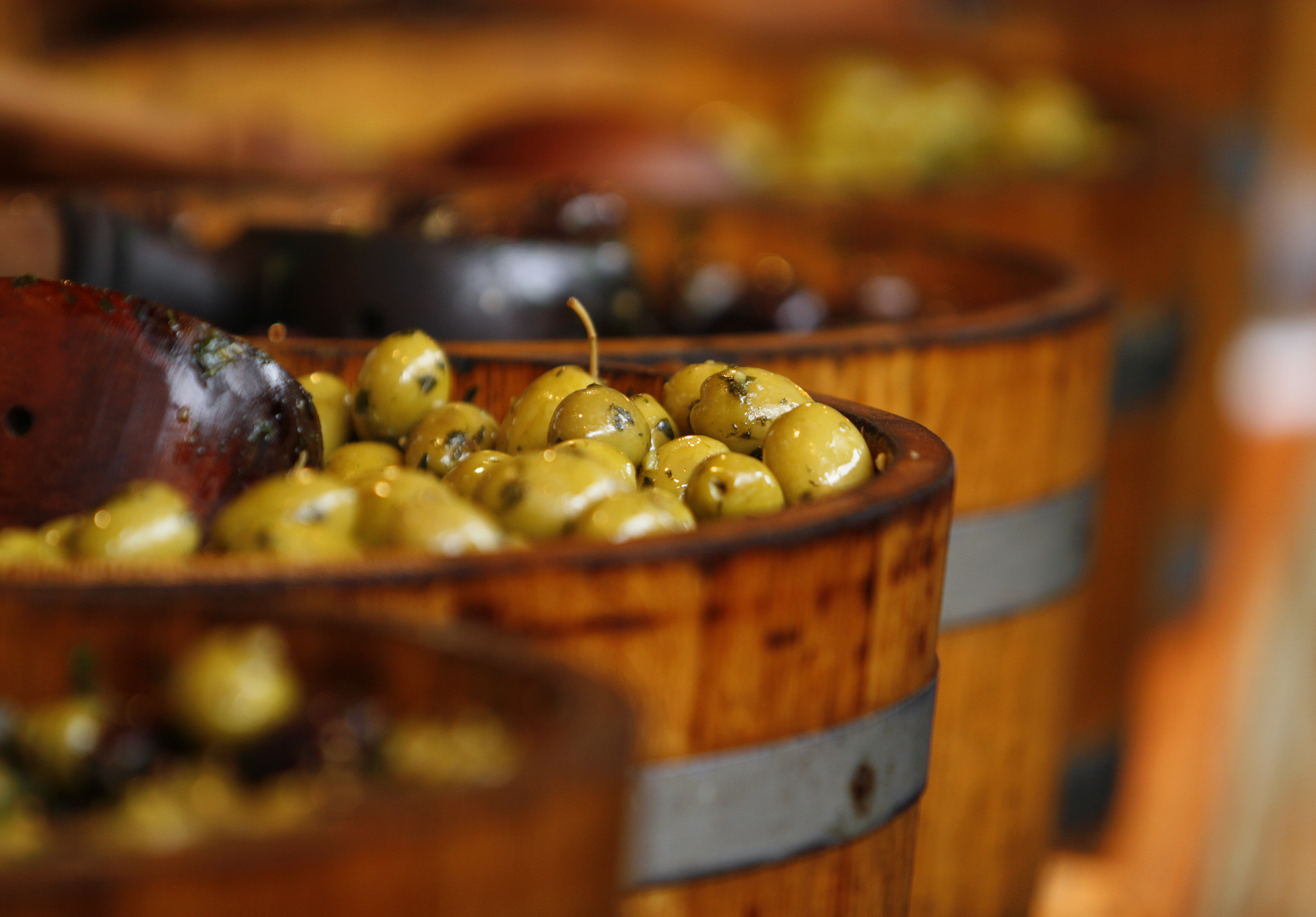 Buckets of olives on display at a market.
