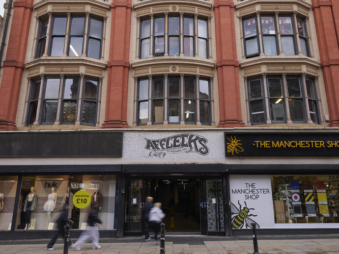Façade d’Afflecks et The Manchester Shop, avec des passants sur le trottoir dans le centre-ville de Manchester.