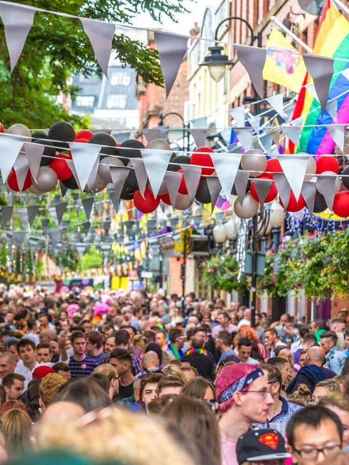 Folla di persone che cammina lungo Canal Street a Manchester