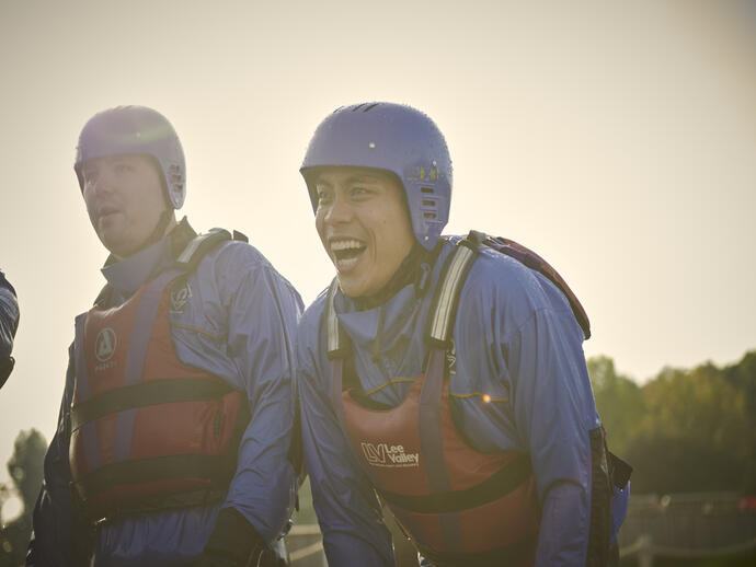 Two men wearing life jackets and helmets
