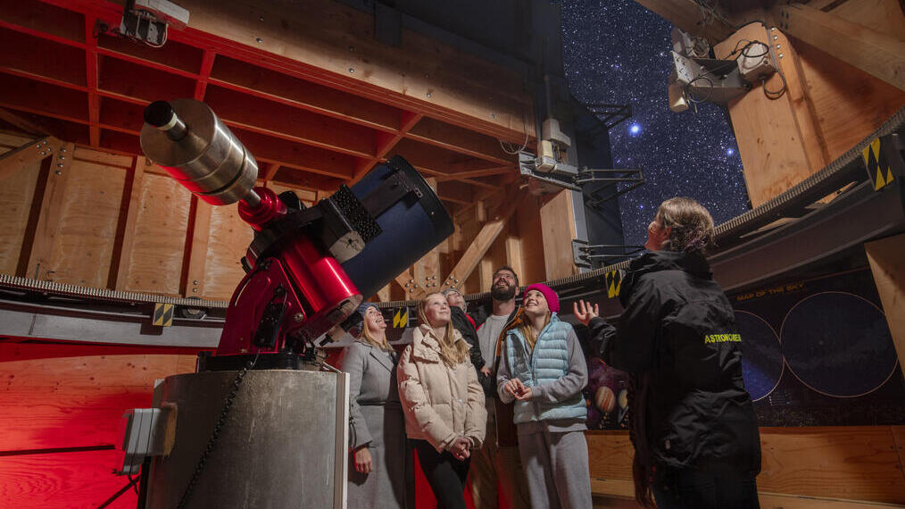 A family stand with a tour guide at an Observatory
