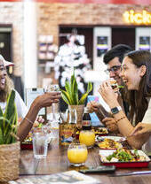 A group of people sitting on a bench eating food at the Storyhouse in Chester