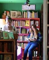 Persone che sfogliano gli scaffali di libri alla libreria Much Ado Books