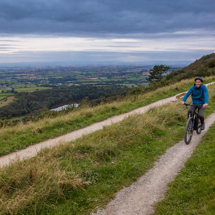 Mann und Frau fahren mit dem Fahrrad auf einem Weg auf einem Bergrücken