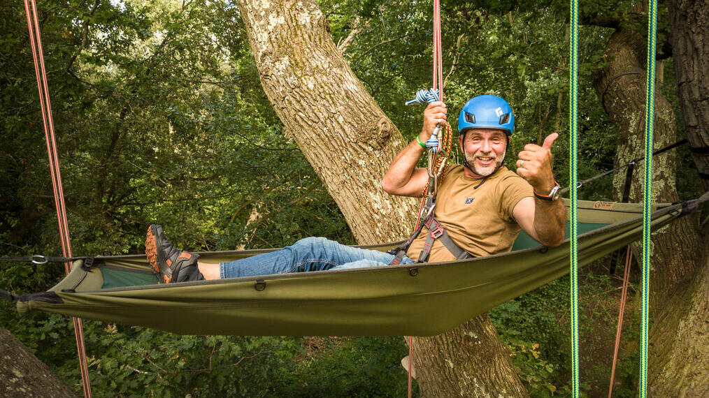 Man hanging from trees in hammock