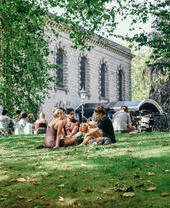 Groups of people sat on a grassy slope in the Jewellery Quarter in Birmingham