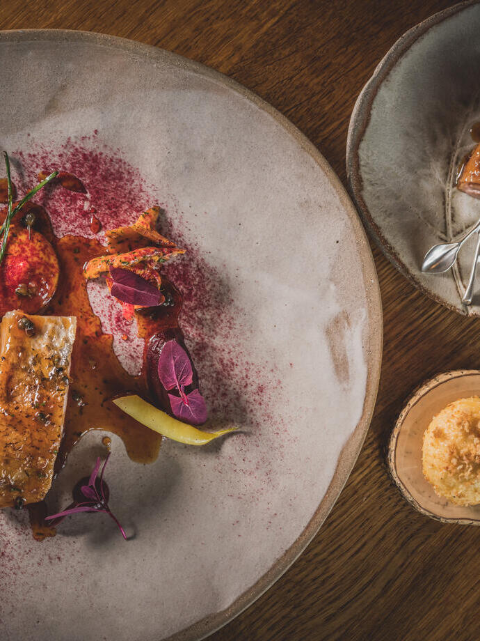 Three different sized plates of colourful food served on rustic grey crockery