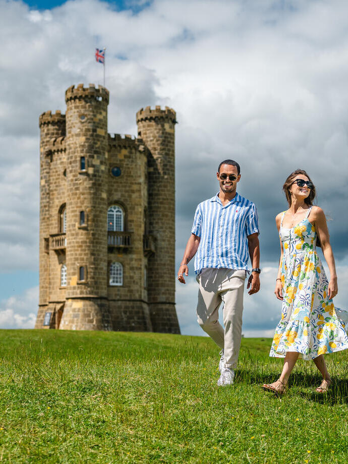 A man and a woman walk in front of an heritage building