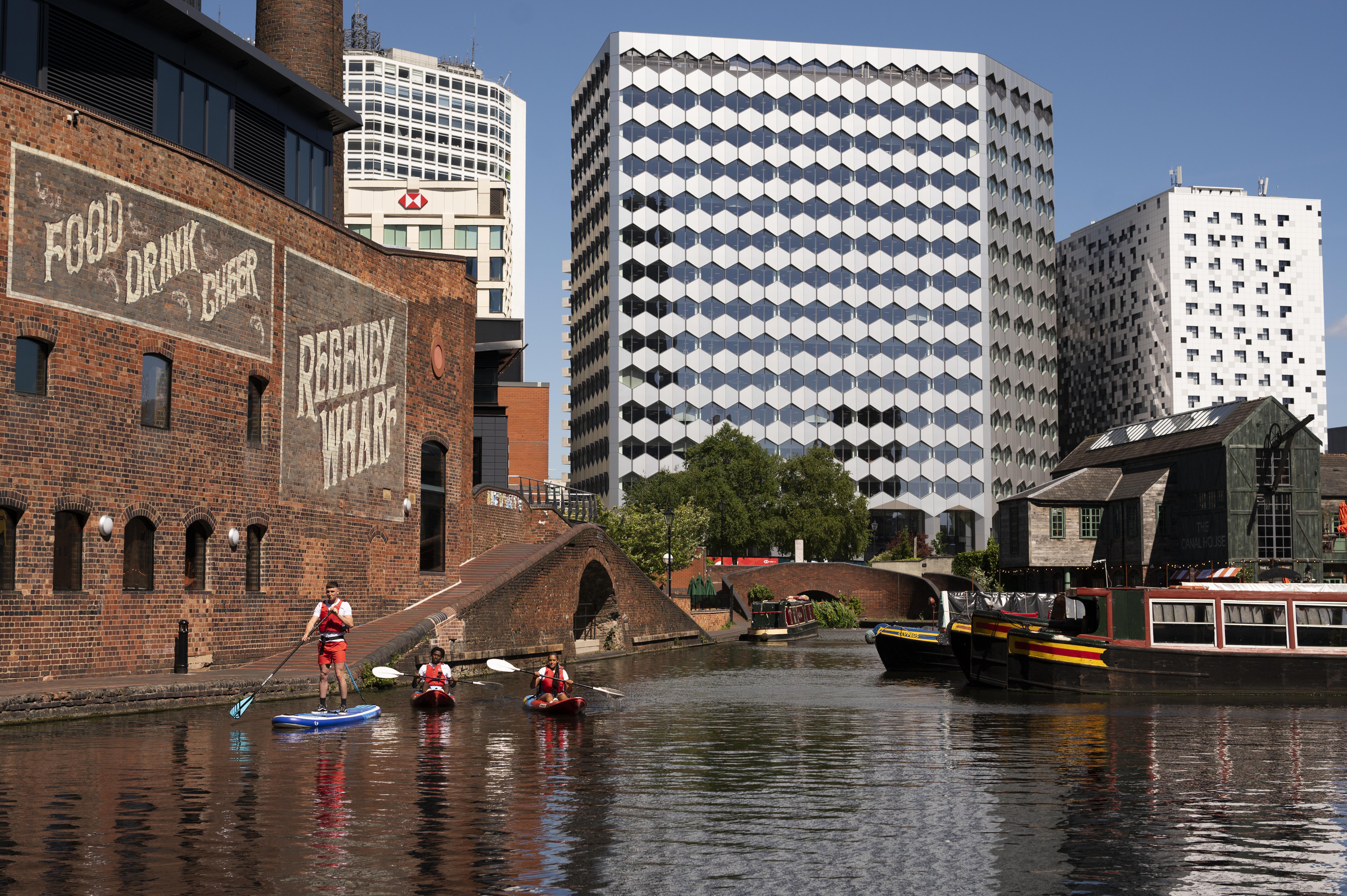 Un groupe de personnes faisant du paddleboard devant le Regency Wharf
