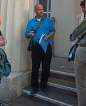 A tour guide talking to a group outside a historic building in Brighton
