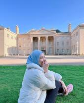 Donna con foulard seduta davanti a Kenwood House