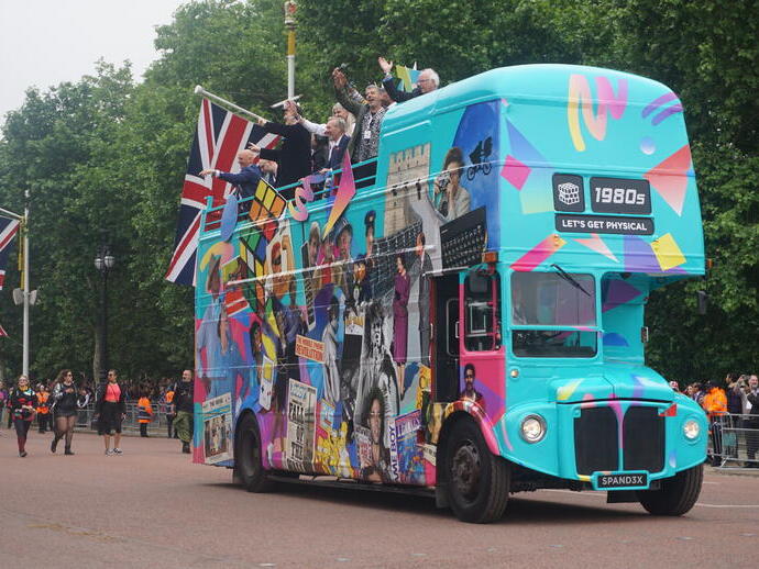 Bild eines blauen Reisebusses mit Union-Jack-Flaggen